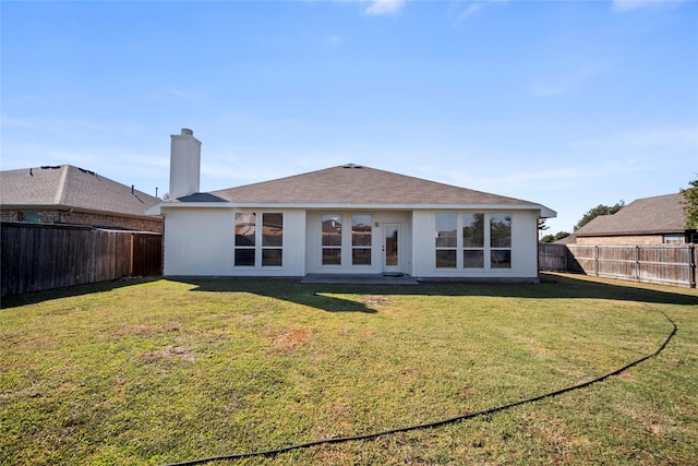 rear view of property featuring a yard