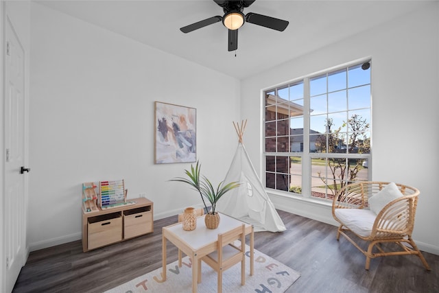 sitting room featuring dark hardwood / wood-style floors and ceiling fan