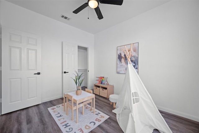 rec room with ceiling fan and dark wood-type flooring