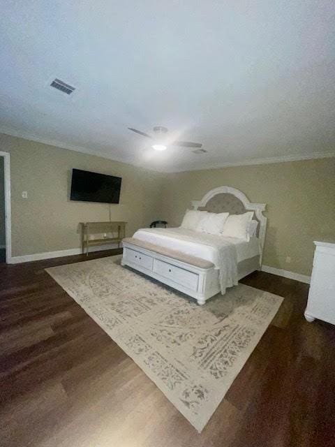 bedroom with dark hardwood / wood-style flooring, ceiling fan, and ornamental molding