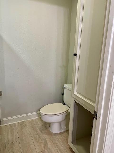 bathroom with toilet and wood-type flooring