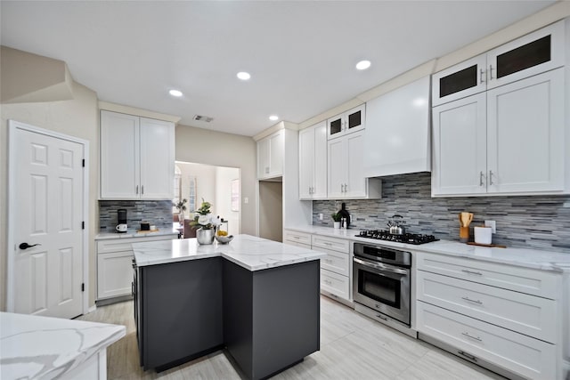 kitchen featuring stainless steel oven, white cabinetry, and gas cooktop