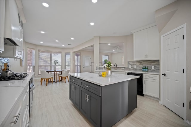 kitchen featuring a center island, white cabinetry, black dishwasher, and stainless steel gas cooktop