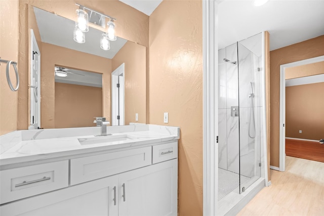 bathroom with vanity, ceiling fan, and a shower with shower door