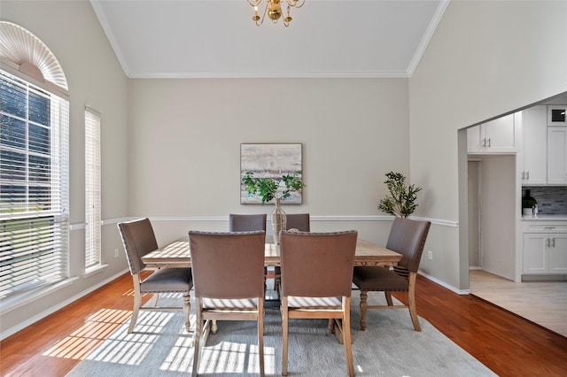 dining room with a chandelier, crown molding, and light hardwood / wood-style flooring