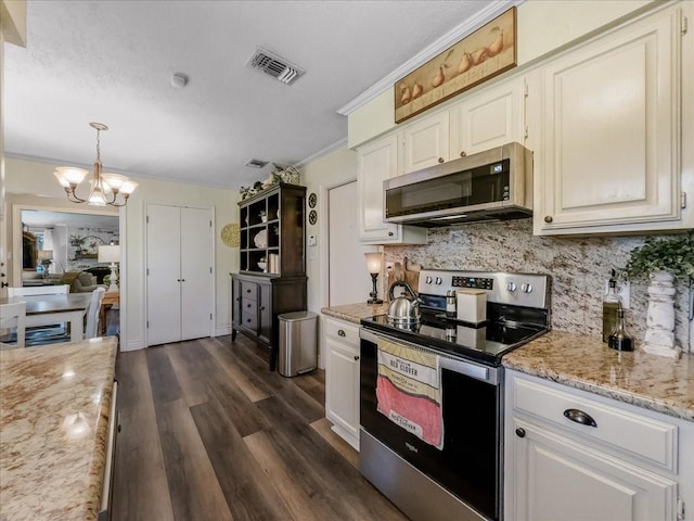 kitchen with stainless steel appliances, an inviting chandelier, decorative light fixtures, decorative backsplash, and ornamental molding