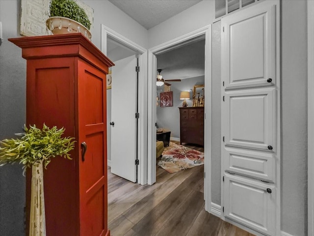 corridor featuring a textured ceiling and hardwood / wood-style flooring