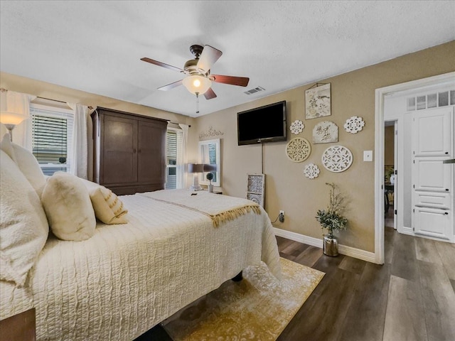 bedroom featuring ceiling fan, dark hardwood / wood-style flooring, and a textured ceiling