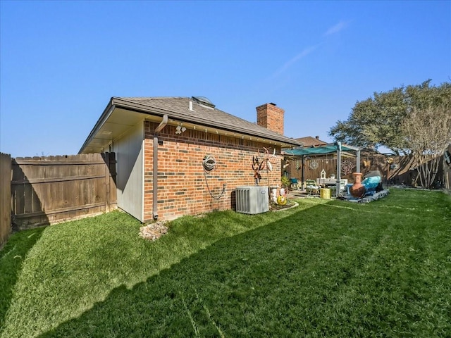 back of house featuring a lawn and central AC