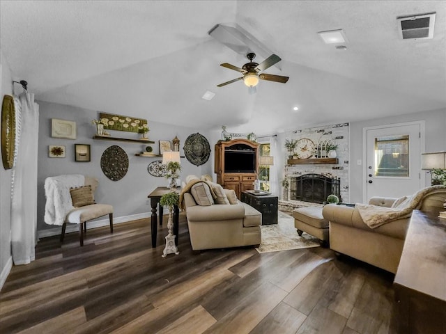 living room with vaulted ceiling, dark hardwood / wood-style floors, ceiling fan, a textured ceiling, and a large fireplace