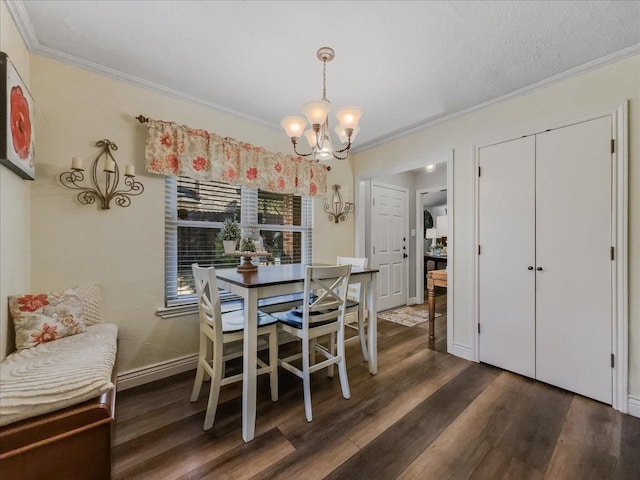 dining space with a textured ceiling, dark hardwood / wood-style flooring, crown molding, and an inviting chandelier