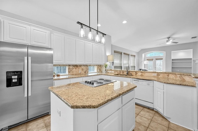 kitchen with ceiling fan, sink, a kitchen island, white appliances, and white cabinets