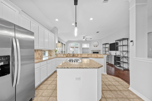 kitchen featuring pendant lighting, a center island, stainless steel appliances, and white cabinetry