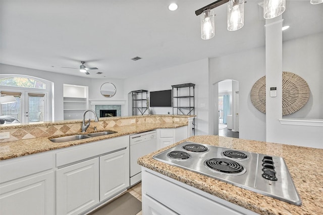 kitchen featuring stainless steel gas stovetop, white cabinetry, dishwasher, and sink