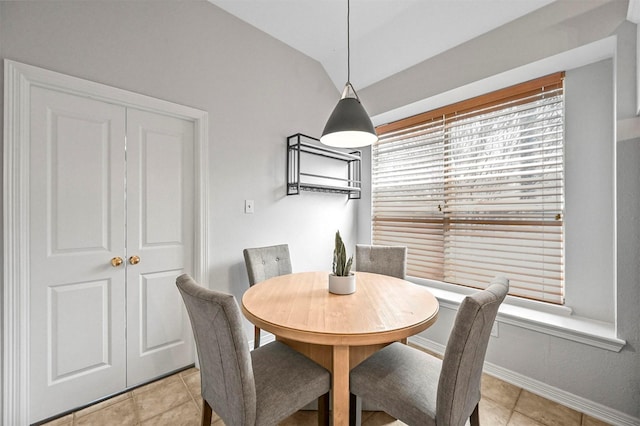 dining room with light tile patterned flooring and vaulted ceiling