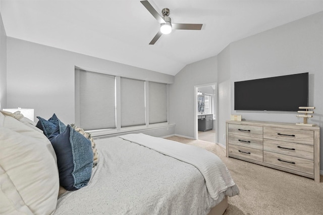 carpeted bedroom featuring vaulted ceiling, ensuite bath, and ceiling fan