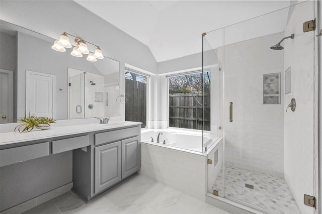 bathroom with vanity, vaulted ceiling, and independent shower and bath