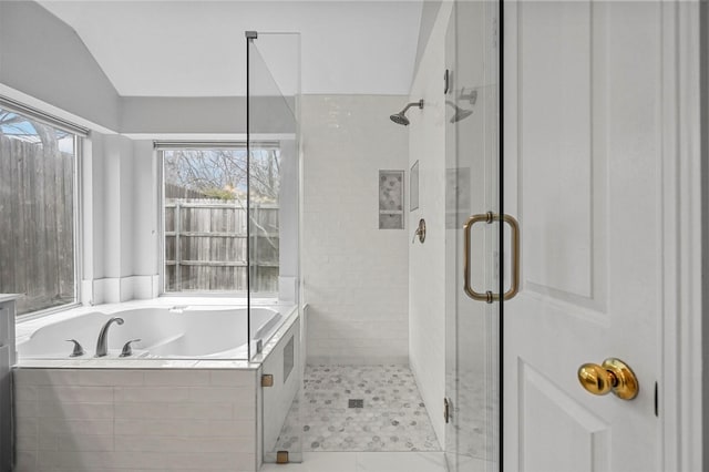 bathroom featuring lofted ceiling and plus walk in shower