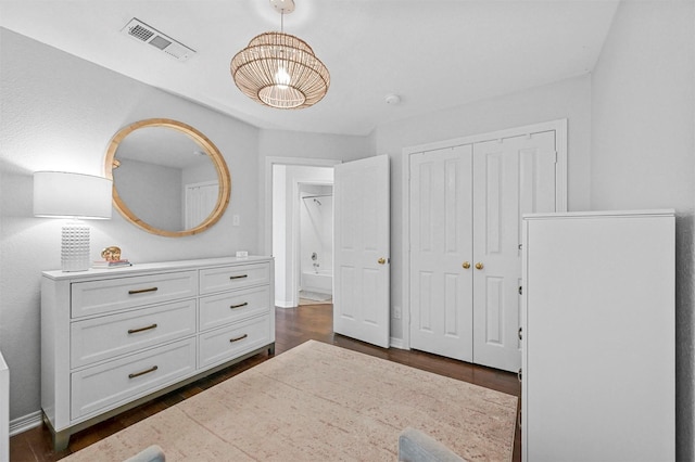 bedroom with dark hardwood / wood-style flooring and a closet