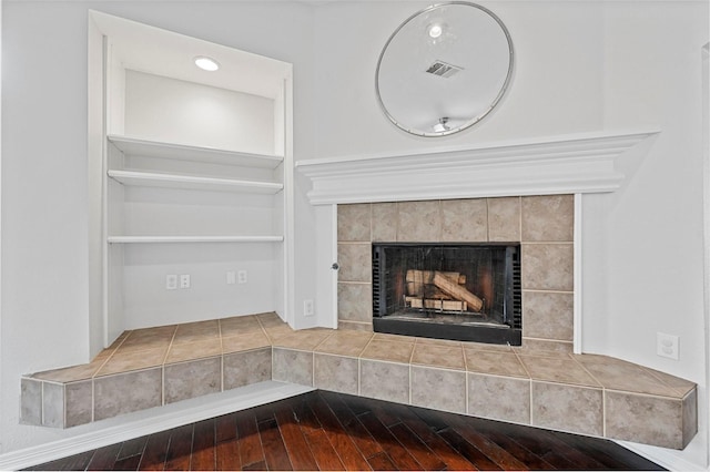 room details featuring hardwood / wood-style flooring and a tile fireplace