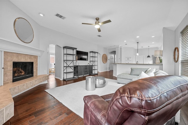 living room featuring a fireplace, a wealth of natural light, dark hardwood / wood-style floors, and ceiling fan