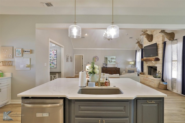 kitchen with dishwasher, gray cabinets, light hardwood / wood-style floors, and a center island with sink