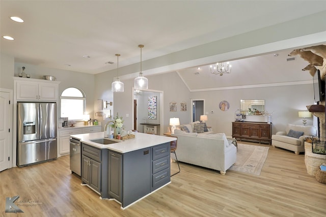 kitchen with white cabinetry, sink, gray cabinetry, stainless steel appliances, and a center island with sink