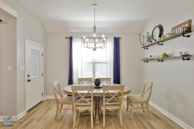 dining area with vaulted ceiling, a chandelier, and light hardwood / wood-style floors