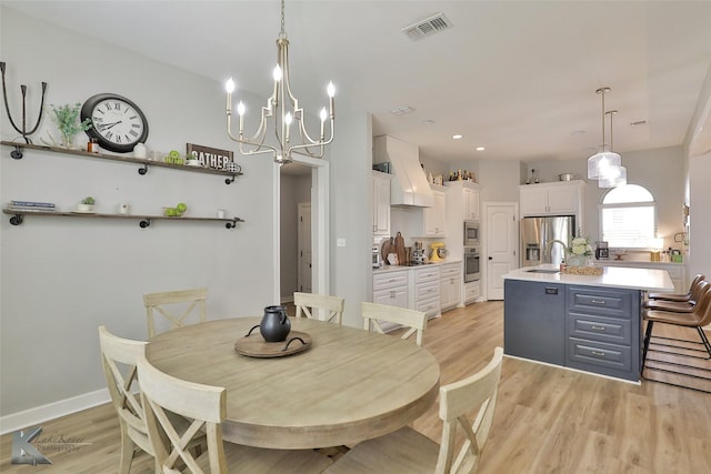 dining area with sink and light hardwood / wood-style floors