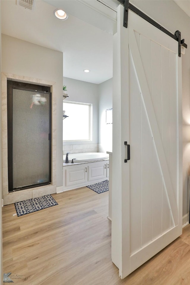 bathroom with wood-type flooring and plus walk in shower