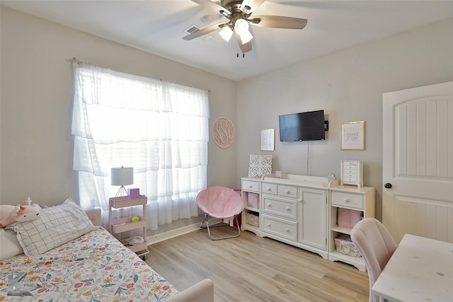 bedroom featuring multiple windows, ceiling fan, and light wood-type flooring