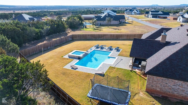 view of swimming pool with a trampoline and a lawn