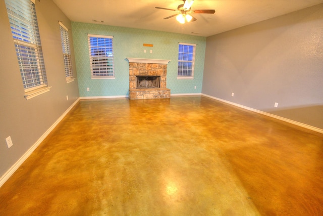 unfurnished living room with concrete flooring, a fireplace, and ceiling fan