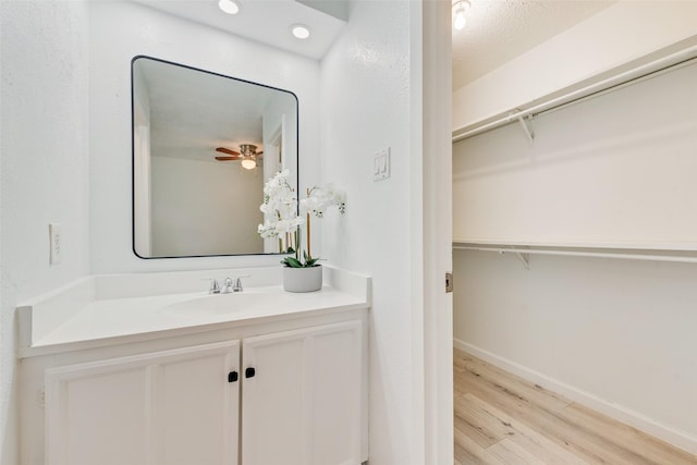 bathroom featuring a textured ceiling, vanity, hardwood / wood-style flooring, and ceiling fan