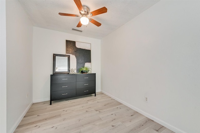 unfurnished bedroom with a textured ceiling, light hardwood / wood-style flooring, and ceiling fan