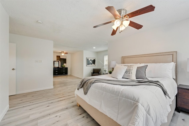 bedroom featuring a textured ceiling, light hardwood / wood-style flooring, and ceiling fan