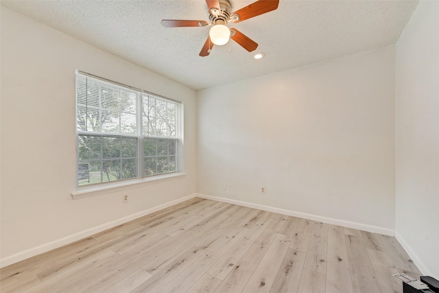 unfurnished room with a textured ceiling, light hardwood / wood-style floors, and ceiling fan