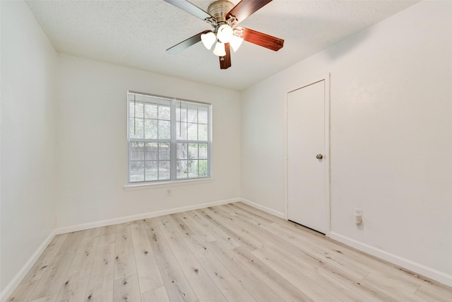 unfurnished room with a textured ceiling, light hardwood / wood-style flooring, and ceiling fan