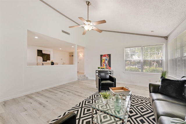 living room featuring a textured ceiling, ceiling fan, light hardwood / wood-style flooring, and lofted ceiling