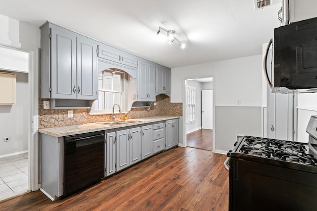 kitchen with tasteful backsplash, sink, range with gas stovetop, and black dishwasher