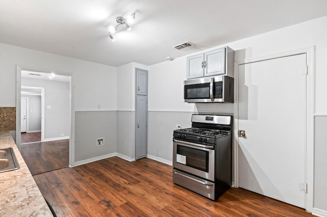 kitchen with dark hardwood / wood-style flooring, sink, gray cabinets, and stainless steel appliances