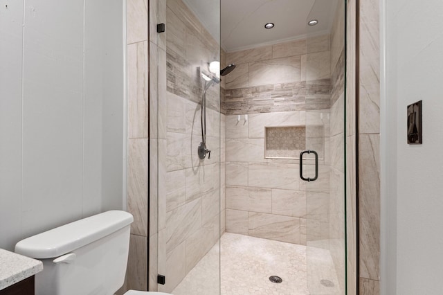 bathroom with vanity, a shower with door, and toilet