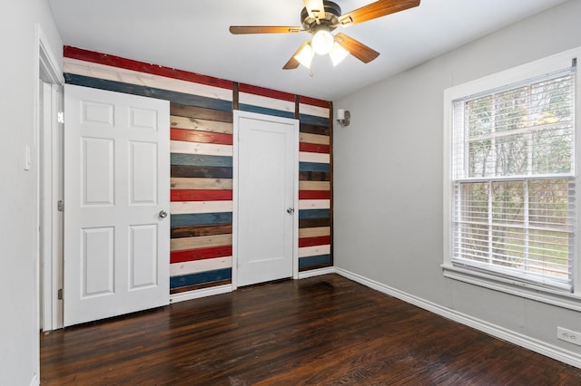 unfurnished bedroom featuring ceiling fan and dark hardwood / wood-style flooring