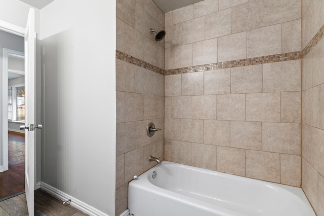 bathroom with wood-type flooring and tiled shower / bath