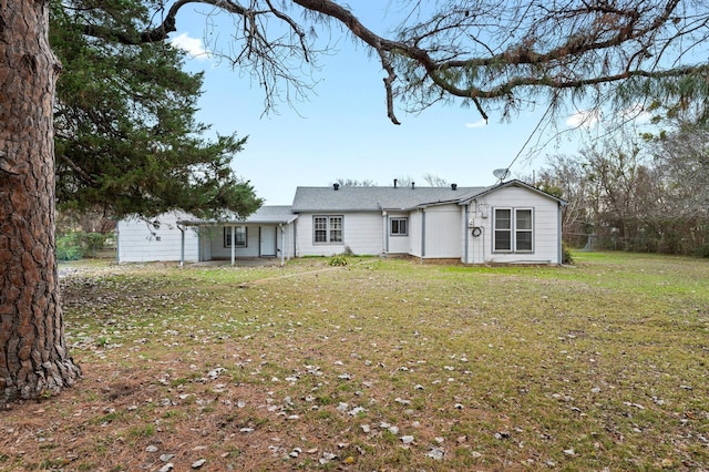 rear view of property featuring a lawn