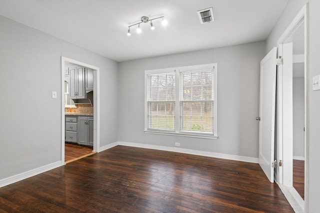 unfurnished dining area featuring dark wood-type flooring