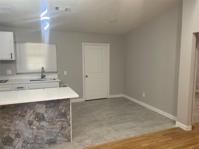 kitchen with white cabinetry and sink