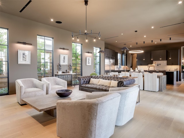 living room featuring a chandelier and light wood-type flooring