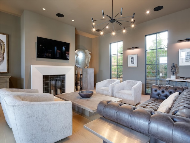 living room featuring light hardwood / wood-style floors, a fireplace, and an inviting chandelier