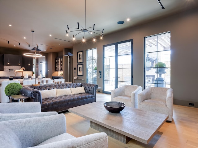 living room featuring light wood-type flooring and a chandelier